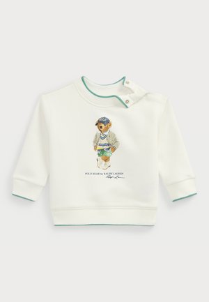 Sudadera blanca de manga larga, con puños y cuello acanalados. Presenta un gráfico impreso de un oso en un traje deportivo y el texto "Polo Bear".
