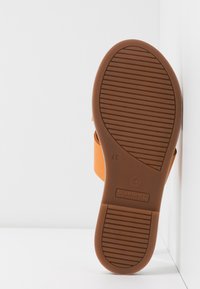 Sandale orange avec une semelle moulée et une semelle extérieure en caoutchouc marron dotée d'un motif antidérapant texturé. Taille 37 indiquée sur la semelle.