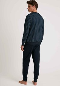 Marineblaues Sweatshirt mit Rundhalsausschnitt, gerippten Bündchen und passenden marineblauen Jogginghosen mit elastischem Bund und schmal zulaufenden Beinen.