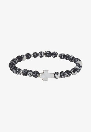 Bracelet en perles marbrées noir et blanc avec un accent en croix argentée, comportant des perles rondes de tailles variées et une texture lisse.