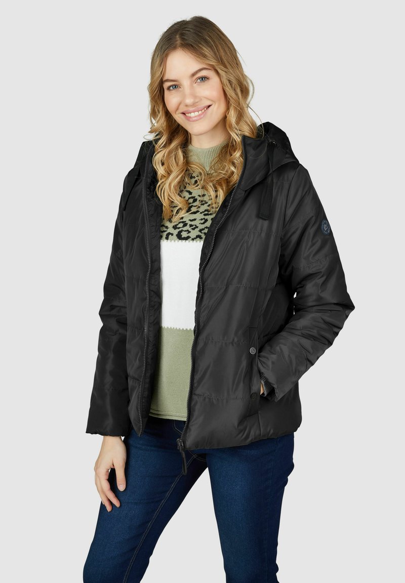 Schwarze isolierte Jacke mit Kapuze, mit einem Reißverschluss vorne, Druckknöpfen und Seitentaschen. Getragen über einem grün-weißen gemusterten Sweater.