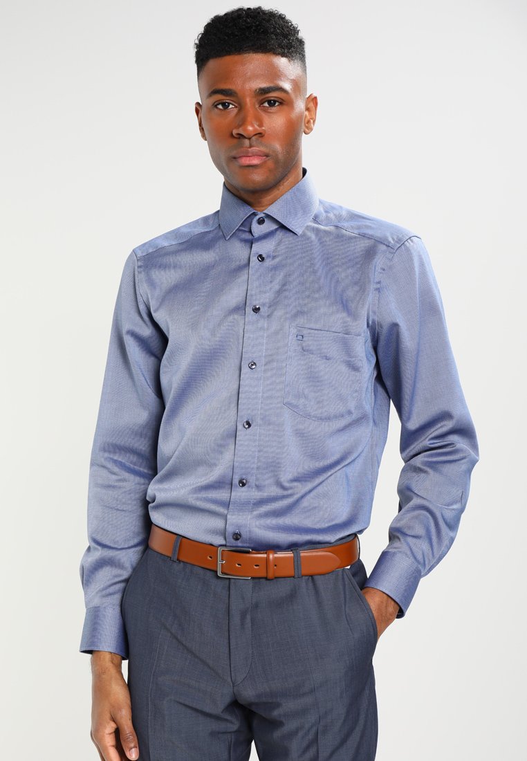Long-sleeve blue button-up shirt with subtle texture, collar, and chest pocket; paired with gray trousers and a brown belt.