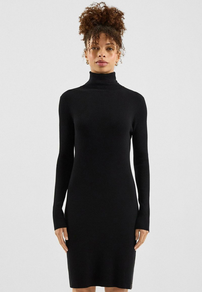 Schwarzes, geripptes Rollkragenkleid aus elastischem Stoff, figurbetonte Silhouette, lange Ärmel und knielanges Design.