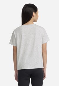 T-shirt gris à manches courtes, en tissu doux, avec une coupe décontractée et un col rond, présenté de dos.