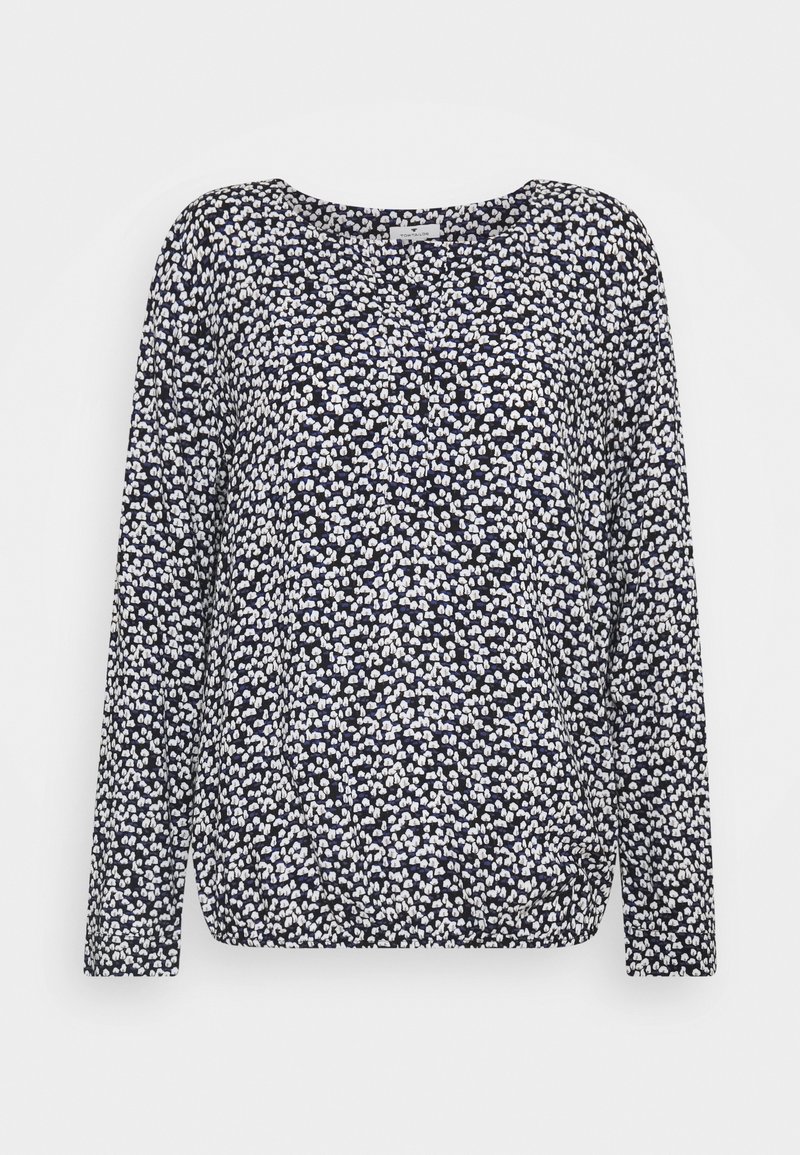 Granatowa bluzka z długim rękawem z białym i jasnoniebieskim abstrakcyjnym kwiatowym wzorem oraz zaokrąglonym dekoltem.