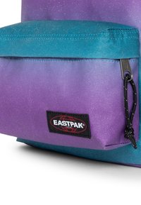 Fioletowo-turkusowy plecak Eastpak o teksturowanym wykończeniu, wyposażony w przednią kieszeń na zamek oraz naszywkę z logo. Projekt zawiera stopniowany układ kolorów.