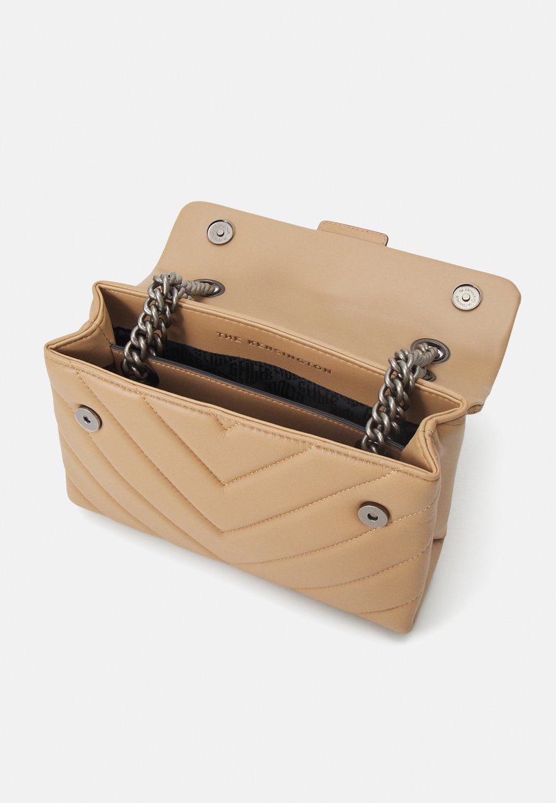 Beżowa torebka skórzana pikowana z łańcuszkiem, srebrnym okuciem i zapięciem na klapkę. Wnętrze wykończone czarną podszewką z logo.