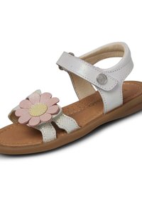 Sandalia de cuero blanco con un detalle de flor en rosa y amarillo, correa ajustable y suela marrón texturizada. Presenta un diseño de punta abierta y recortes.