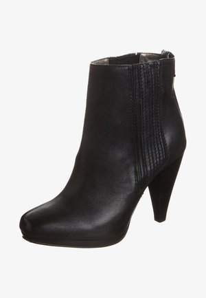 Bottine en cuir noir avec talon haut empilé, panneaux élastiques latéraux, bout arrondi et fermeture éclair à l'arrière.