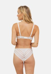 Soutien-gorge blanc et culotte assortie avec des accents en dentelle. Le soutien-gorge a des bretelles fines et une fermeture à crochet ; la culotte présente un motif de dentelle géométrique à l'arrière.