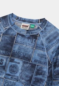 Blauwe katoenen sweatshirt met een retro print van verschillende labels en logo's, voorzien van een ronde hals en raglan mouwen. Eco-collectie label zichtbaar.