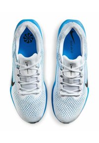 Buty sportowe Nike z dominującą białą siateczką, niebieskimi akcentami, czarnym logo swoosh i standardowym sznurowanym zapięciem.