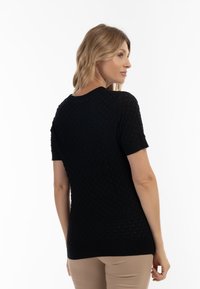 Pulover negru cu mânecă scurtă, cu un model texturat în diamant, dintr-un material tricotat neted, guler rotund și un design ajustat în talie.