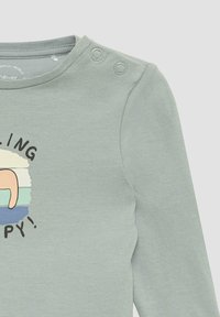 Lichtgroene babyshirt met lange mouwen en twee drukknoopjes op de schouder, met gedeeltelijke grafische tekst en een kleurrijk ontwerp.