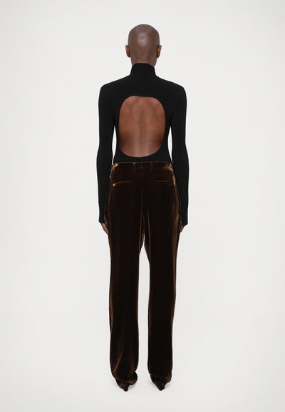 Zwarte bodysuit met lange mouwen en een grote open rug, gecombineerd met bruine fluwelen wijde broek. Glad textuur en aansluitend ontwerp.