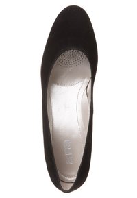 Zwarte suède platte schoen met een ronde neus, voorzien van een glad metallic interieur en kleine geperforeerde details voor ademend vermogen.