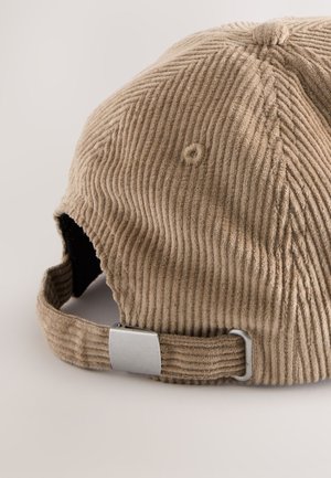 Corduroy cap in light brown with vertical rib texture. Features a metal adjustable strap and a circular button detail on top.