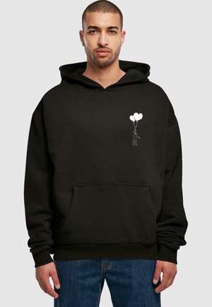 Black hoodie made of soft fabric, featuring a front pocket and a white graphic of a figure holding two balloons on the left chest.