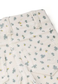 Witte corduroy shorts met een bloemmotief in blauw en geel. Geborduurd konijndetail op de achterzak, gestructureerd oppervlak.