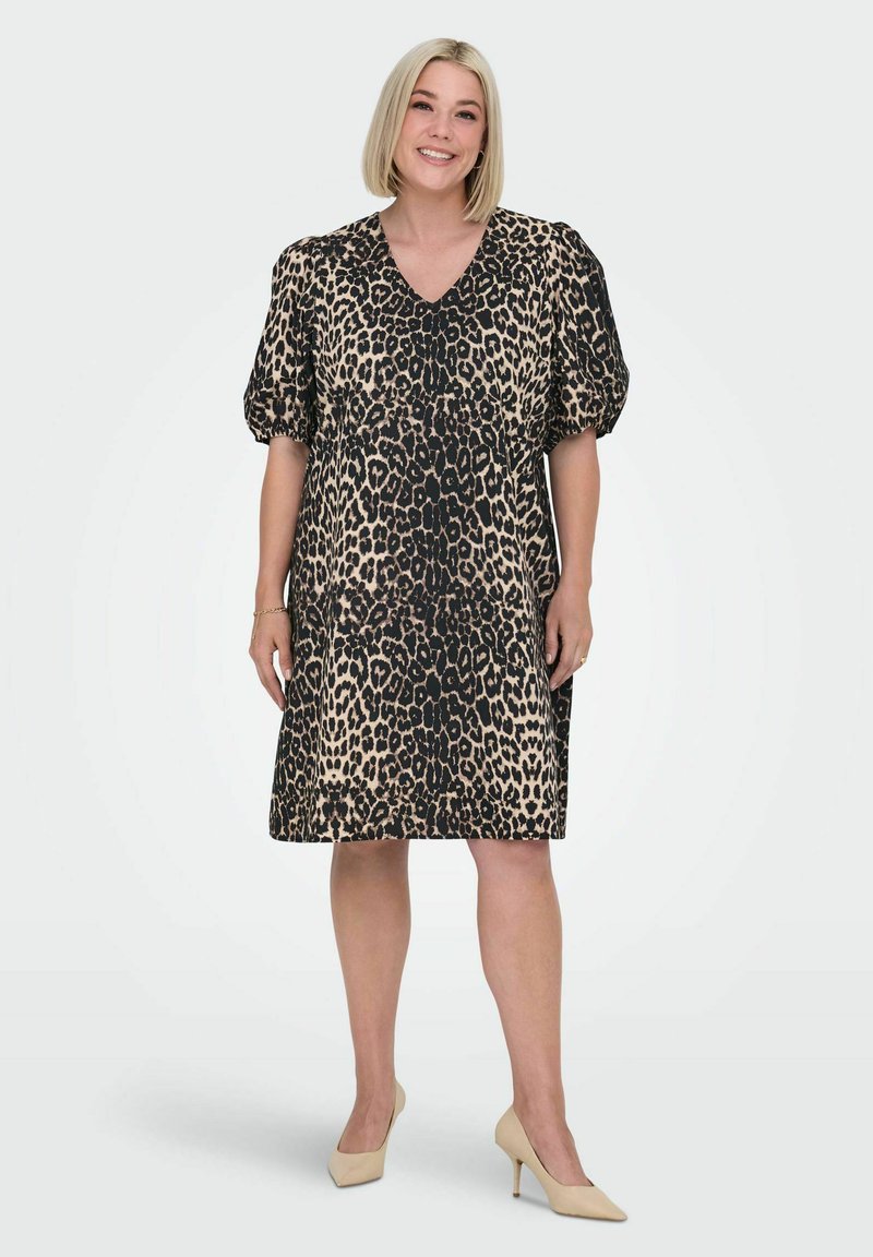 Leopardmönstrad klänning i beige och svart, med V-hals och korta puffärmar, löst sittande och knälång design.