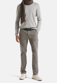 Grå långärmad skjorta, sandfärgade chinos med lätt glans, svart skärp, brun ribbad halsduk och cremefärgade sneakers med gummisulor. Minimalistisk design.