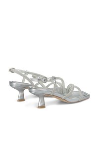 Zilveren sandalen met hak en een strappy ontwerp, met een vierkante teen, verstelbare gesp en textuuraccenten op de banden.