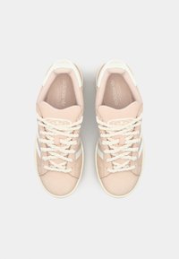 Svijetlo ružičaste suede tenisice s bijelim naglascima, pletenim vezicama i teksturiranom potplatom. Adidas logo vidljiv na jeziku i sa strane.