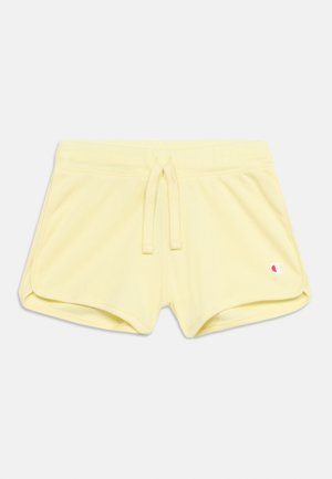 Bløde gule træningsshorts med elastisk linning, snøre, afrundede sidesømme og et lille Champion-logo på venstre forben foran.
