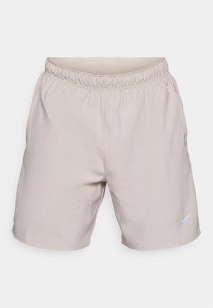 Beżowe szorty sportowe z elastycznym pasem i bocznymi kieszeniami. Posiadają małe, jasnoniebieskie logo Nike na lewej nodze. Gładka tekstura.