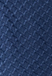 Tessuto texturizzato blu navy con un motivo a diamante e dettagli in rilievo, che offre una superficie tattile. Ideale per rivestimenti o accessori.
