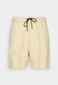 Herrshorts i ljusgul bomullsblandning. Har en elastisk midja med en svart dragsko och sidofickor. Diskret logotyp p å benet.