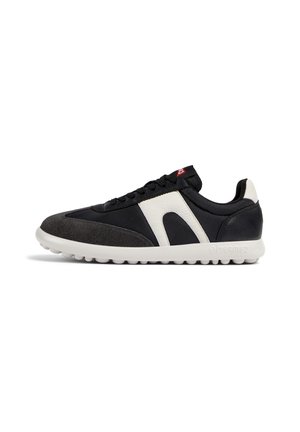 Sort-hvid lav sneakersko med tekstureret sål, sorte snørebånd, ruskindstippe og en hvid logodetalje på siden, vist i profil.