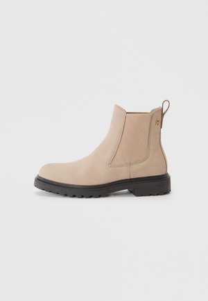 Stivale Chelsea in suede beige con pannelli laterali elastici, linguetta e suola in gomma robusta con una finitura leggermente texturizzata.