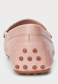 Pink leather shoe with a rounded back, featuring brown rubber studs for grip. Textured surface and simple design without embellishments.