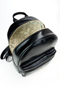 Zaino in pelle nera con texture a coccodrillo, zip dorata e interno beige con un motivo sottile. Include spallacci regolabili.