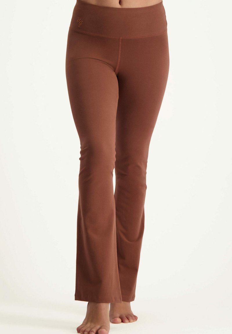 Braune, ausgestellte Leggings aus weichem Stoff mit einem breiten Bündchen und dezentem Logo. Glatte Textur, durchgehendes Design und ohne Muster.