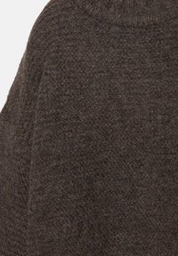 Tessuto di maglione in lana marrone con motivo a maglia testurizzato, che mostra un aspetto morbido e peloso e un colore ricco e intenso.