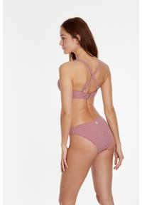 Bikini od dva dijela s geometrijskim uzorkom u ružičastoj boji, s preklopnim naramenicama i umjerenim pokrivačem. Tkanina je meka i glatke teksture.
