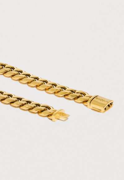 Náramek zlatého řetězu s propletenými články a bezpečnou sponou. Hladký povrch s lesklým finišem, který účinně odráží světlo.