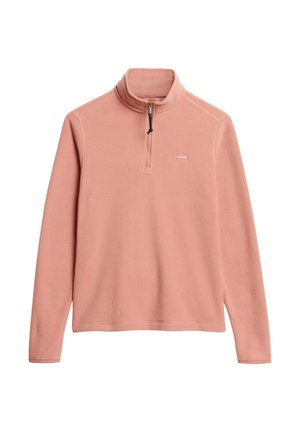 Pull en polaire rose avec un col zippé moitié, arborant un patch logo sur la poitrine et une surface douce et texturée. Manches longues avec des poignets ouverts.