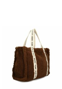 Bruine nepbont schoudertas met crèmewitte schouderbanden met daarop gedrukte tekst. Zachte textuur en rechthoekige vorm met een ruime binnenkant.