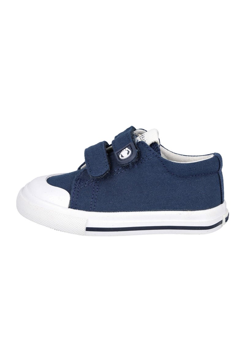 Zapatilla de lona azul marino con puntera y suela de goma blanca, que cuenta con dos cintas de velcro y un acento de logo en el lateral.