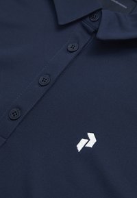Navyblaue Poloshirt aus glattem Stoff mit einer Knopfleiste mit drei Knöpfen und einem weißen Logo auf der Brust. Strukturiertes Kragen- und Ärmeldesign.