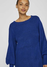 Blå oversize-tröja med texturerad stickning, bred båturringning och långa ballongsärmar. Mjuk tyg med en mysig utseende.
