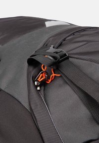 Sac à dos en tissu noir avec une finition texturée, doté d'un cordon de fermeture éclair orange et d'une pince en plastique noir pour une fermeture sécurisée.
