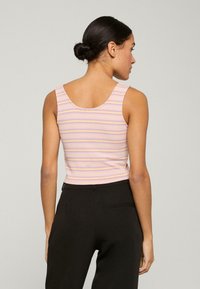 Stribet tanktop i lyserød med lilla og hvide vandrette striber. Har en scoop-back design og et tætsiddende, strækbart materiale.