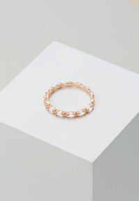 Ring aus Roségold mit einem wellenförmigen Banddesign und abwechselnd angeordneten klaren, ovalen Steinen, die in krallenartigen Fassungen eingesetzt sind. Glatte Textur, erhöhtes Design.