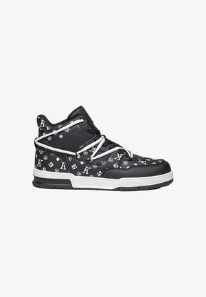 Zapatilla alta negra de piel sintética con patrones y logotipos blancos. Presenta cordones blancos y una gruesa suela blanca con acentos negros.
