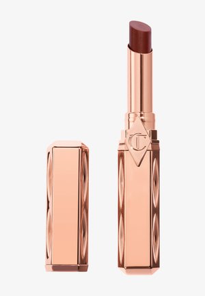 Tube de rouge à lèvres métallique or rose avec le capuchon enlevé, révélant un raisin de rouge à lèvres brun foncé et un logo gravé sur le boîtier.