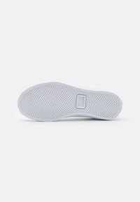White sneaker sole with a herringbone pattern, smooth texture, and a logo plate. The edge is slightly rounded for a sleek appearance.